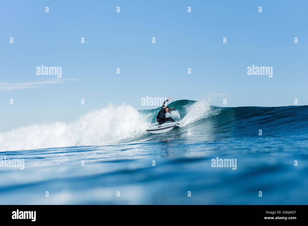 Mann surft und macht ein Surfmanöver auf einer Welle im Meer Stockfoto