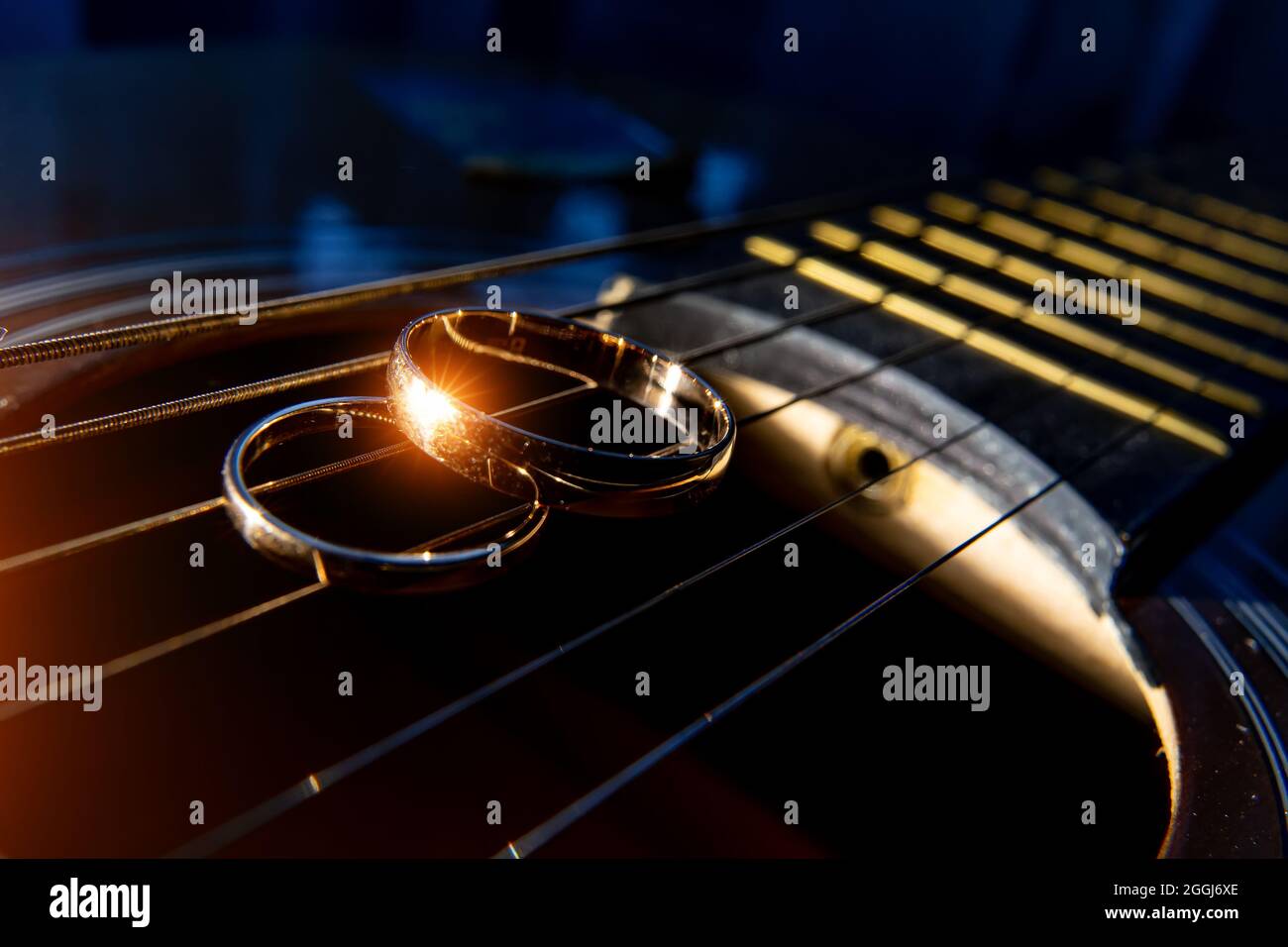 Eheringe auf Gitarrensaiten Nahaufnahme auf dunklem Hintergrund. Stockfoto