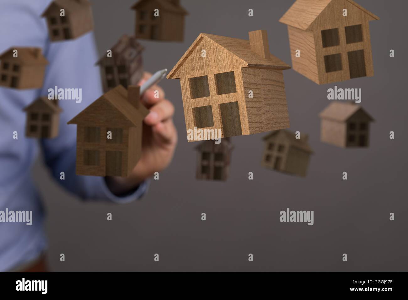 Männliche Hand zeigt auf Illustrationen von weißen Häusern für Immobilien Stockfoto