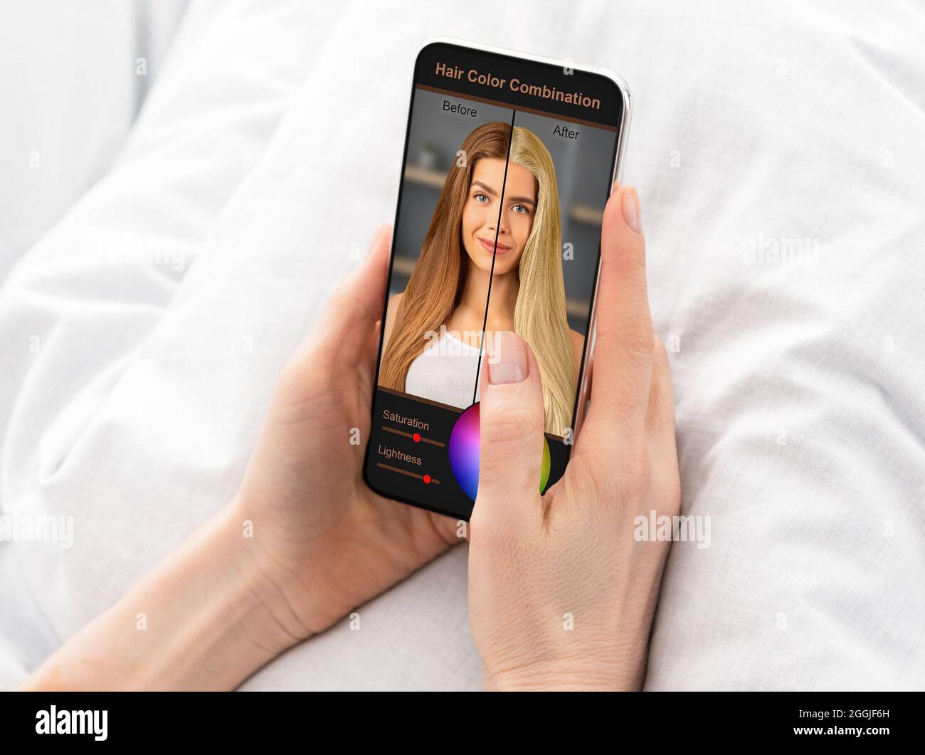 Frau, die neue Haarfarbe wählt, mit der mobilen App auf dem Handy Stockfoto