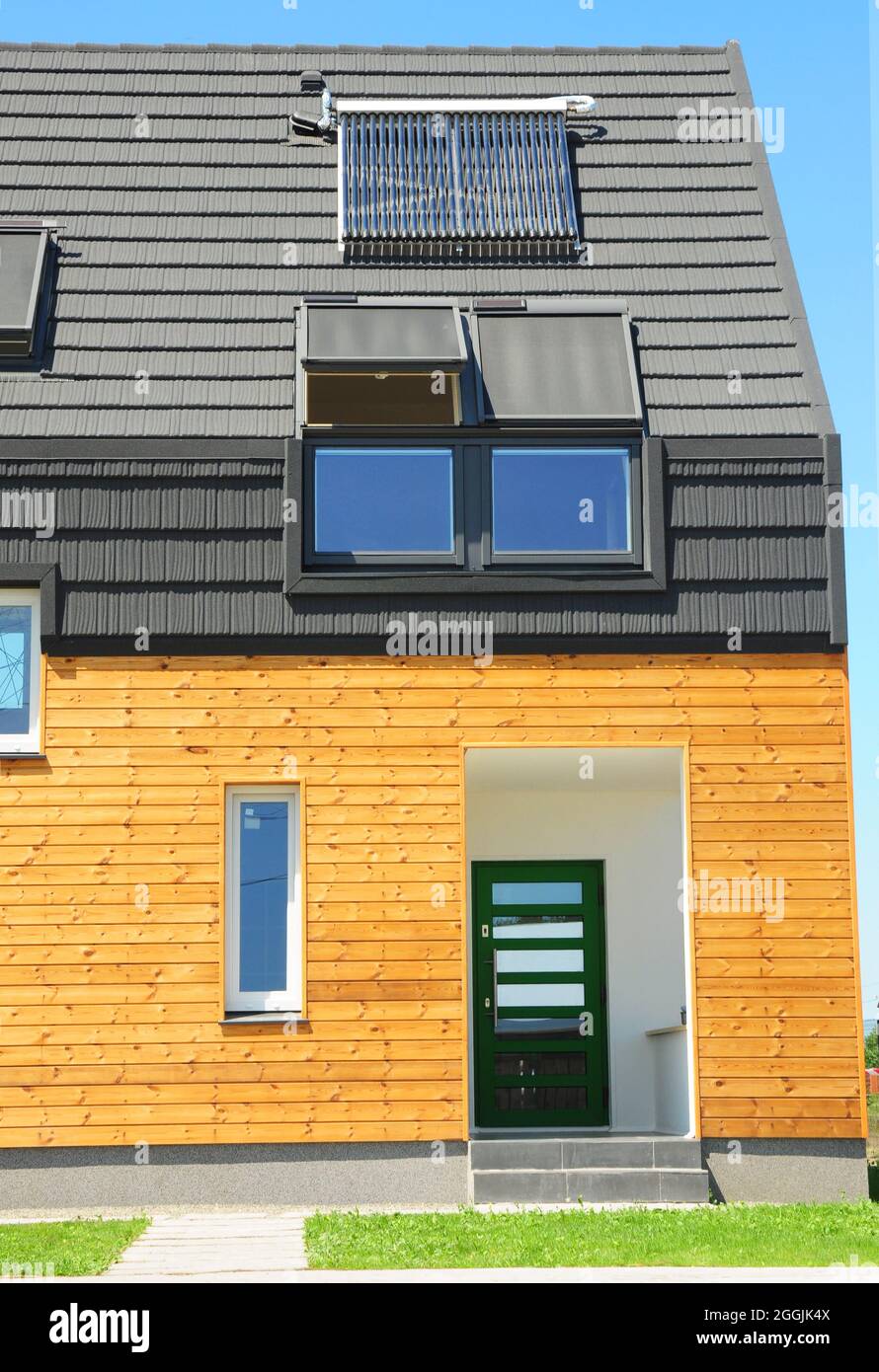Modernes Haus mit Energieeinsparung und Energieeffizienz. Öko-Haus mit Dachfenster, Isolierung, Sonnenkollektoren und Solar-Warmwasserbereiter (SWH)-System. Stockfoto