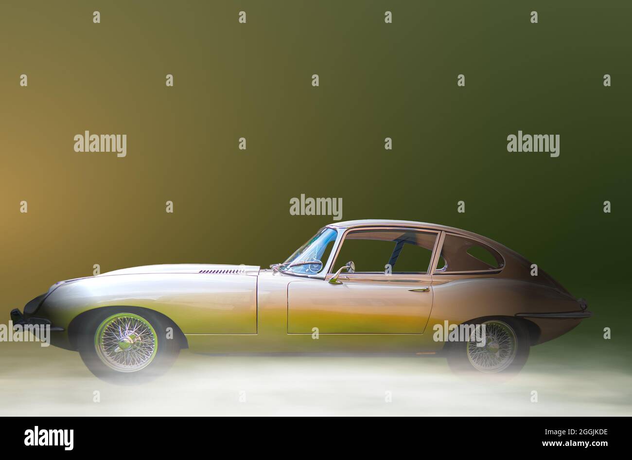 Jaguar E Type 4.2, isoliert in Seitenansicht vor neutralem Gefälle-Hintergrund mit Bodennebel in Lehnin, Deutschland, 21. August 2021,illustratives EDITO Stockfoto