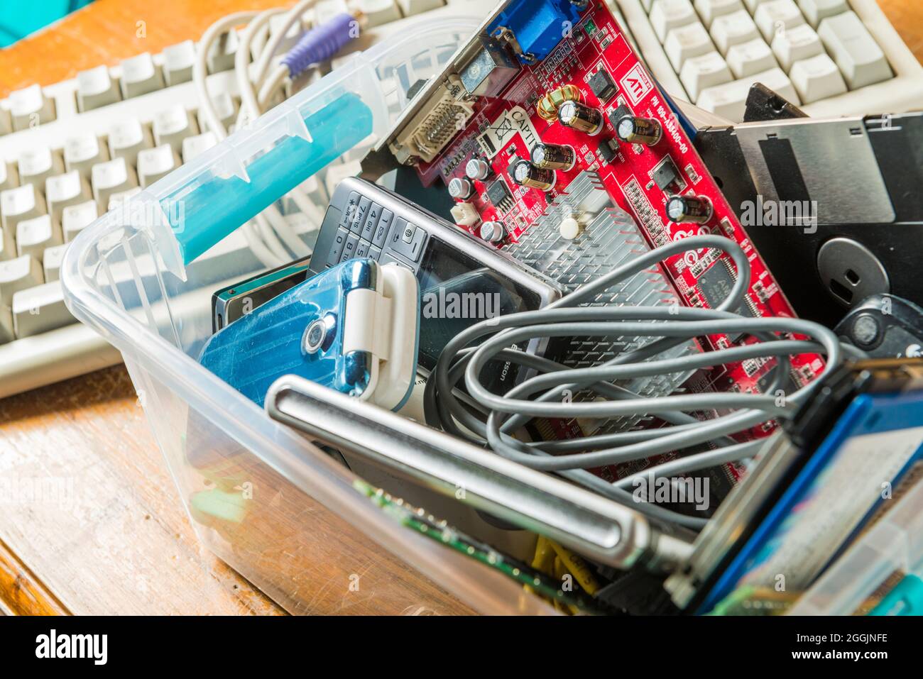Computertastaturen und veraltete elektronische und technologische Objekte in einer Kunststoffbox. Technologische Abfälle und deren Recycling sind eines der Themen, die b Stockfoto