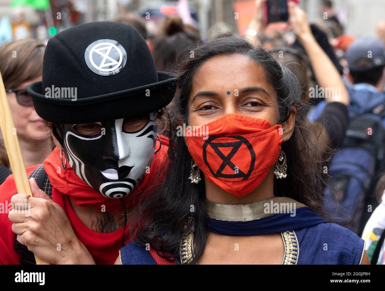 Junge asiatische Frau bei einem Protest gegen die Auslöschung der Rebellion vor der Bank of England, London, Großbritannien. August 2021. Tragen einer XR-Gesichtsmaske Stockfoto