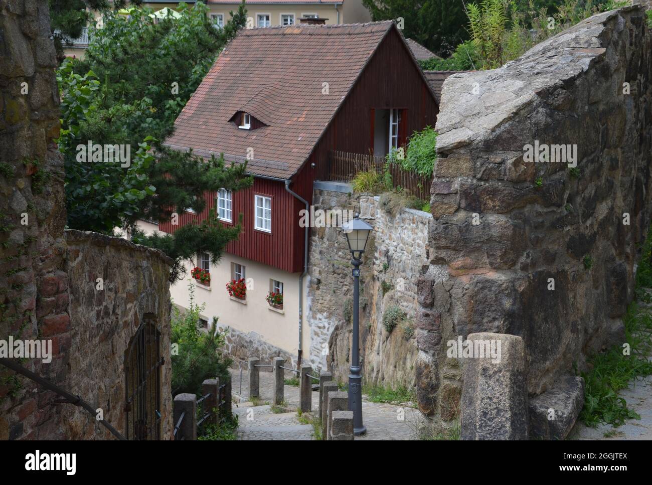 Steile Gasse mit einer alten Mauer und historischen Gebäuden in Bautzen Stockfoto