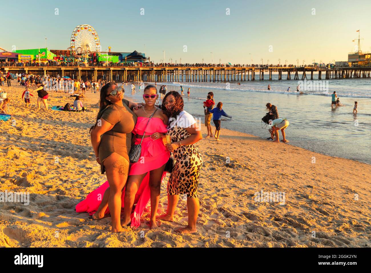 Drei junge Frauen posieren am Santa Monica Beach, Santa Monica, Kalifornien, USA Stockfoto