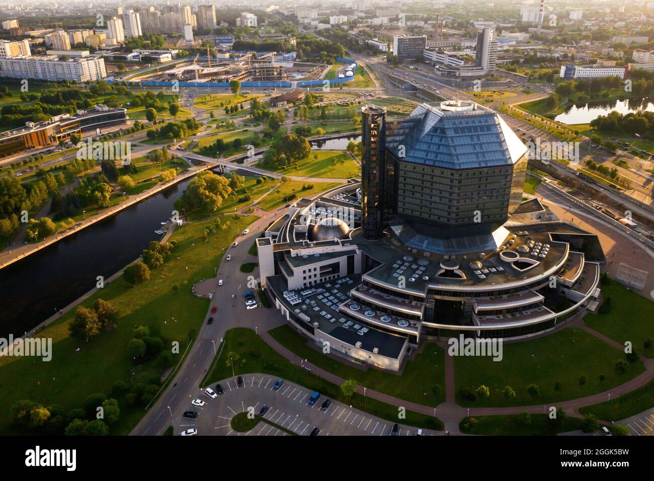 Draufsicht auf die Nationalbibliothek und ein neues Viertel mit einem Park in Minsk-der Hauptstadt der Republik Belarus bei Sonnenuntergang, ein öffentliches Gebäude. Stockfoto