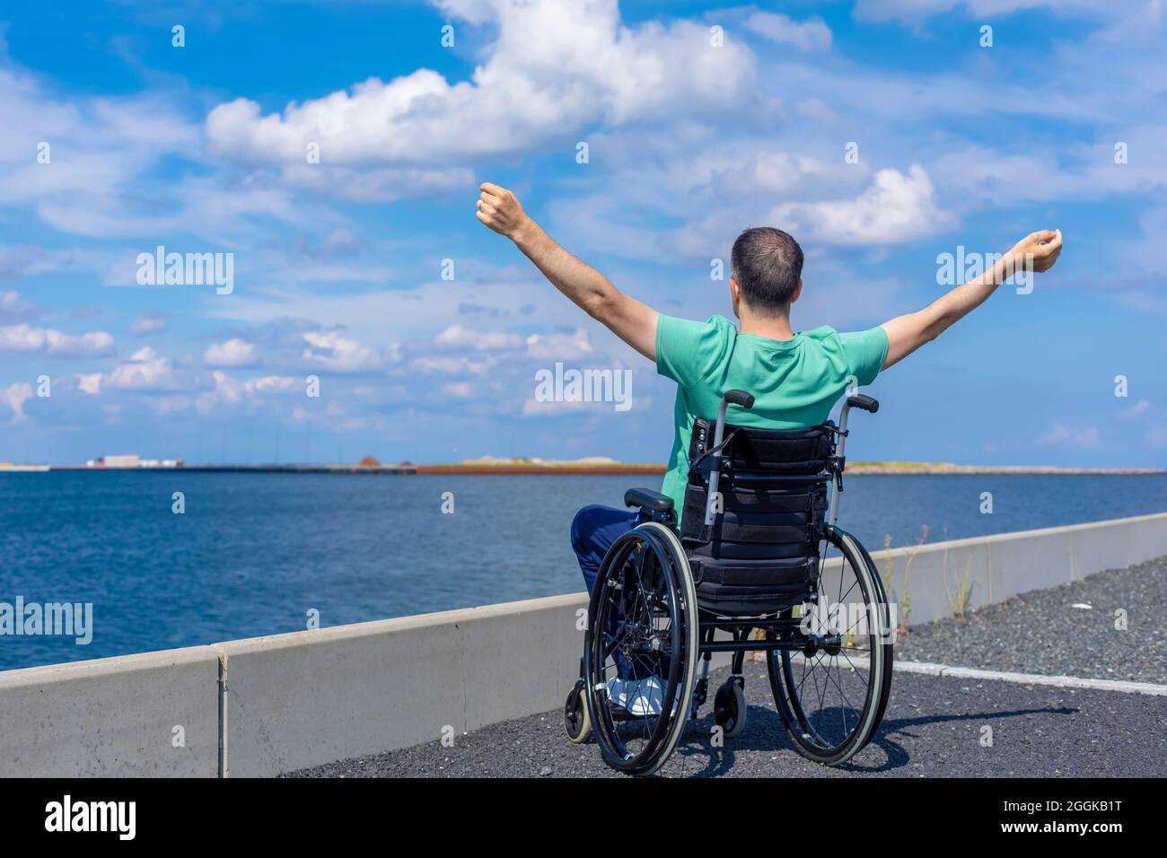 Behinderter Mann im Rollstuhl, der das Meer bewundert. Reise-, Bewegungs- und Freiheitskonzept. Stockfoto