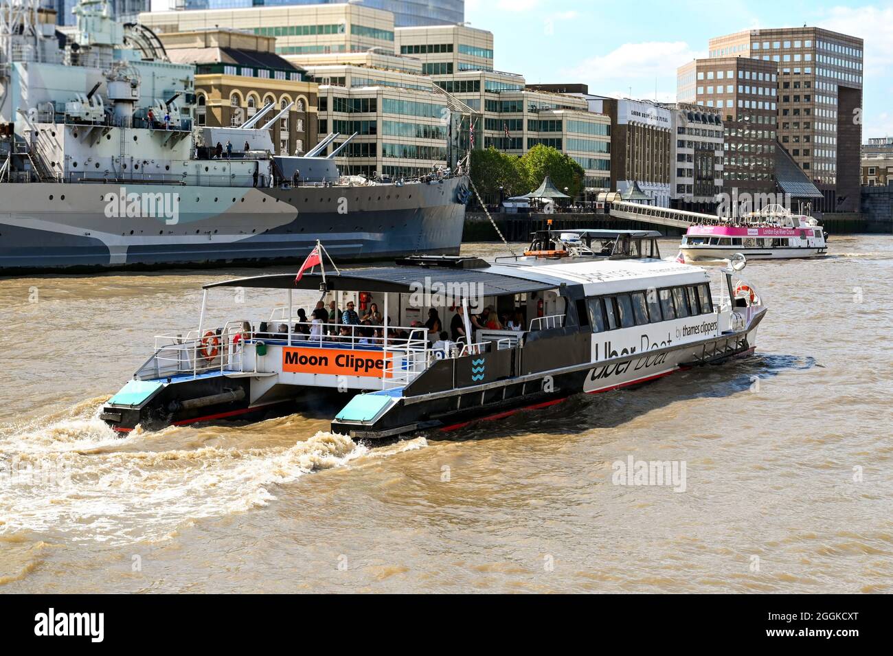 London, England - 2021. August: Seitenansicht eines Wassertaxis von Thames Clipper auf der Themse. Die Fähre wird von Uber gesponsert. Stockfoto