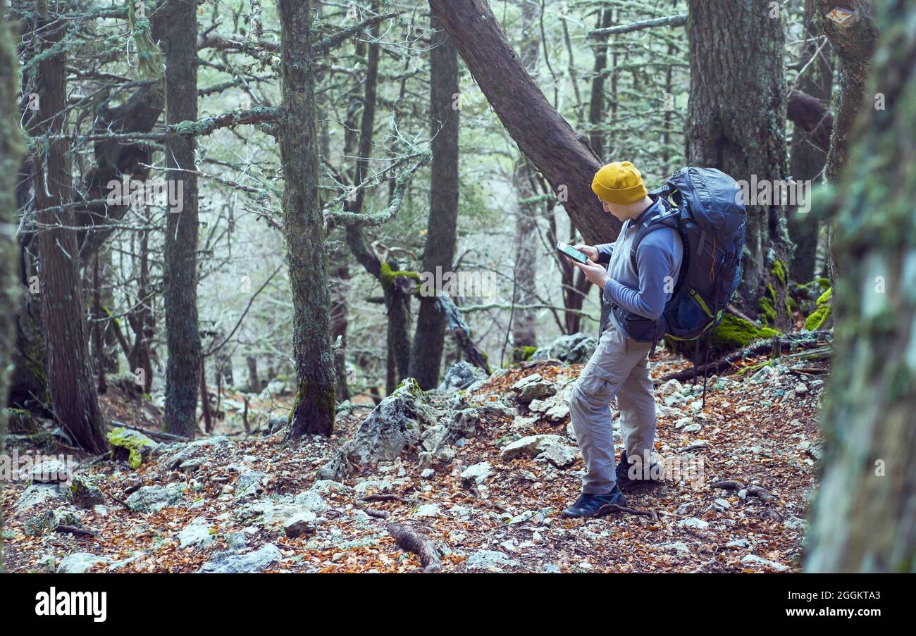 Ein junger Mann geht im Frühjahr auf einem Bergwanderweg. Stockfoto