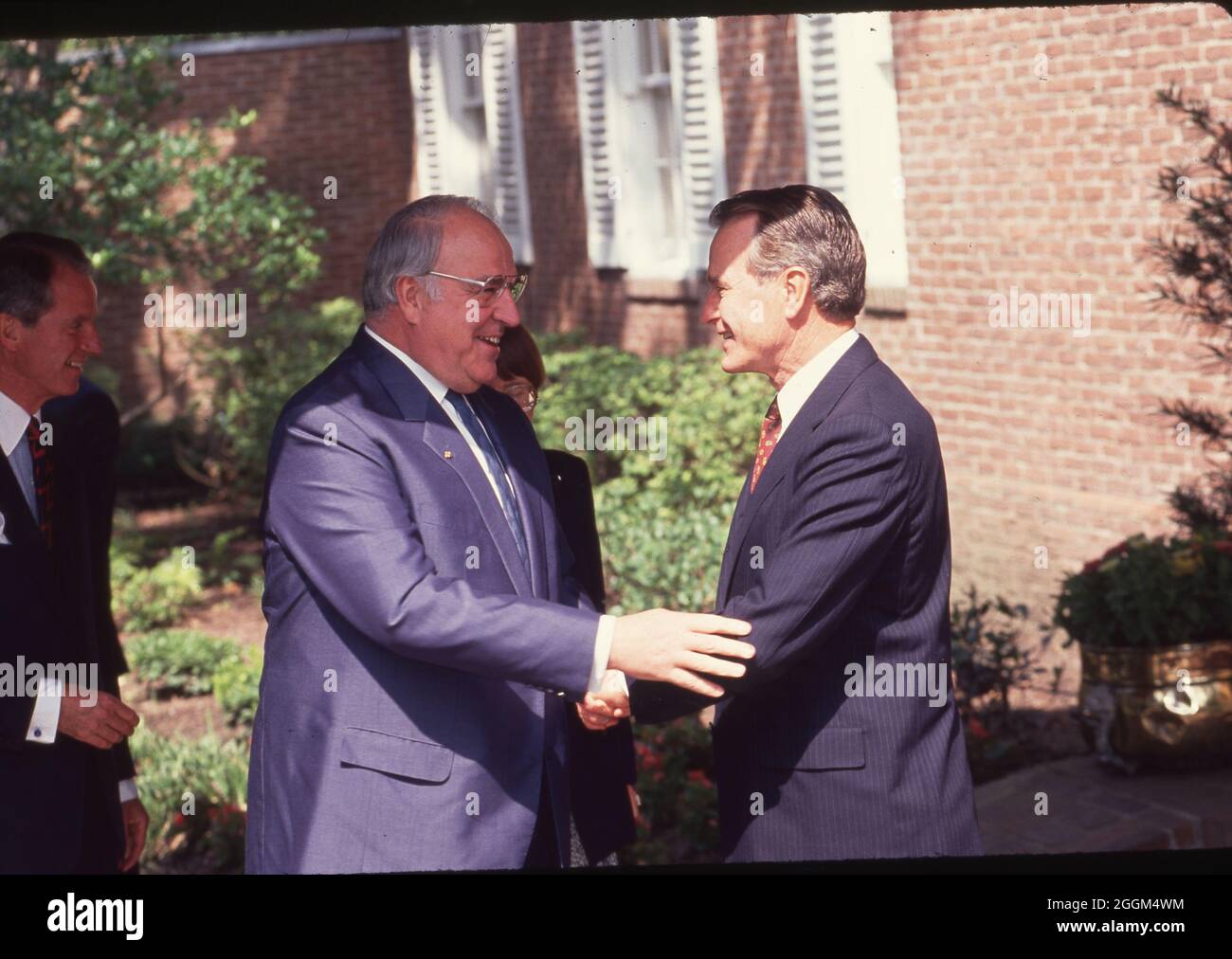 Houston Texas USA, Juli 1990: Bundeskanzler Helmut Kohl, links, schüttelt sich die Hände mit Präsident George H.W. Bush beim Houston Economic Summit of Industrialized Nations auf einer Pressekonferenz im Freien auf dem Campus der Universität von Reis. ©Bob Daemmrich Stockfoto