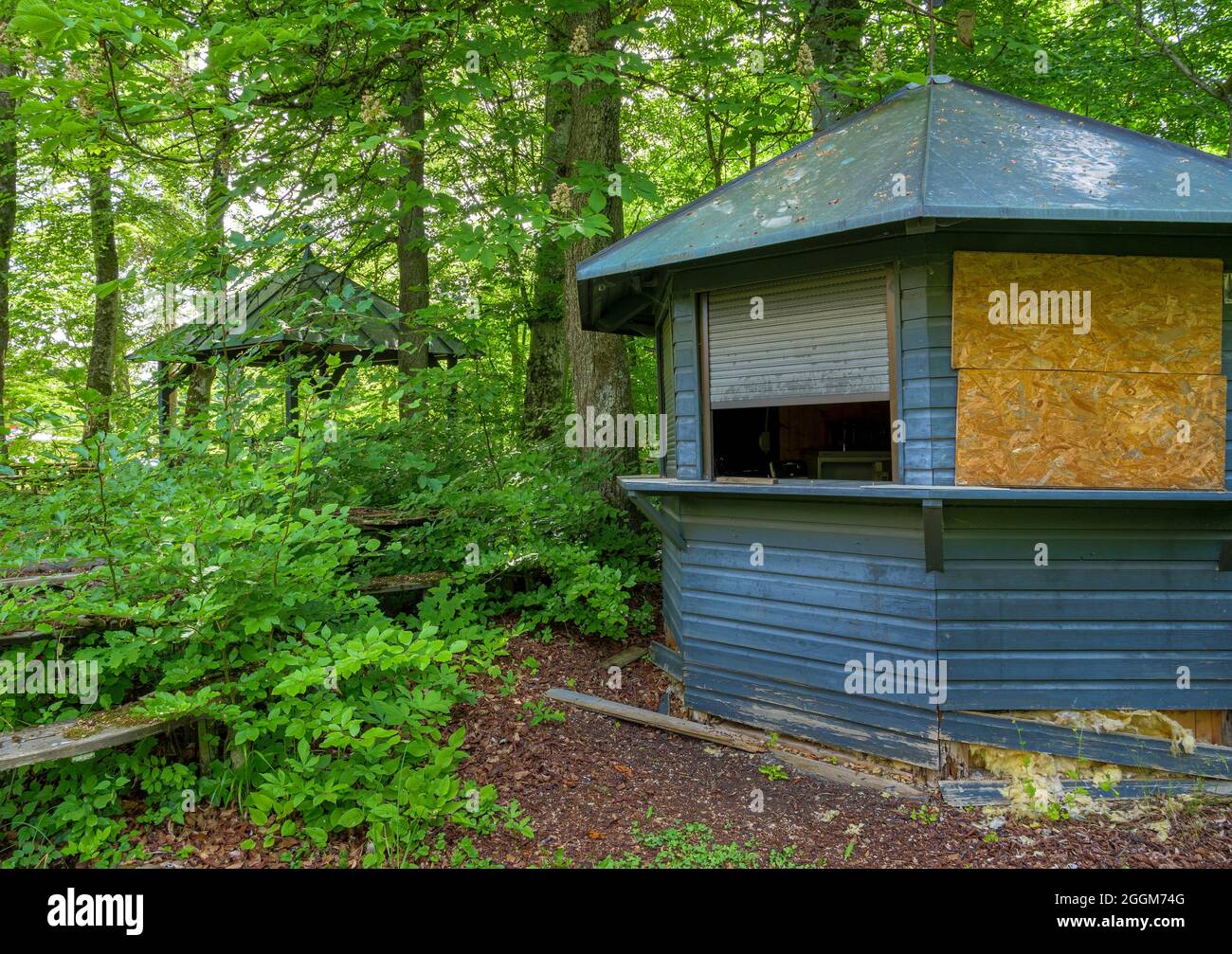 Lost Place, bewachsener Biergarten mit moosbedeckten Sitzbereichen, Gasthof Obermühltal, Bayern, Deutschland, Europa Stockfoto