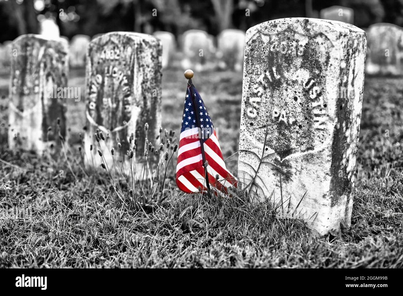 Farblich mit Graustufenfoto einer kleinen amerikanischen Flagge, die die Gräber von Todesopfern auf dem Antietam National Cemetery in Sharpesburg, Maryland, markiert. Stockfoto