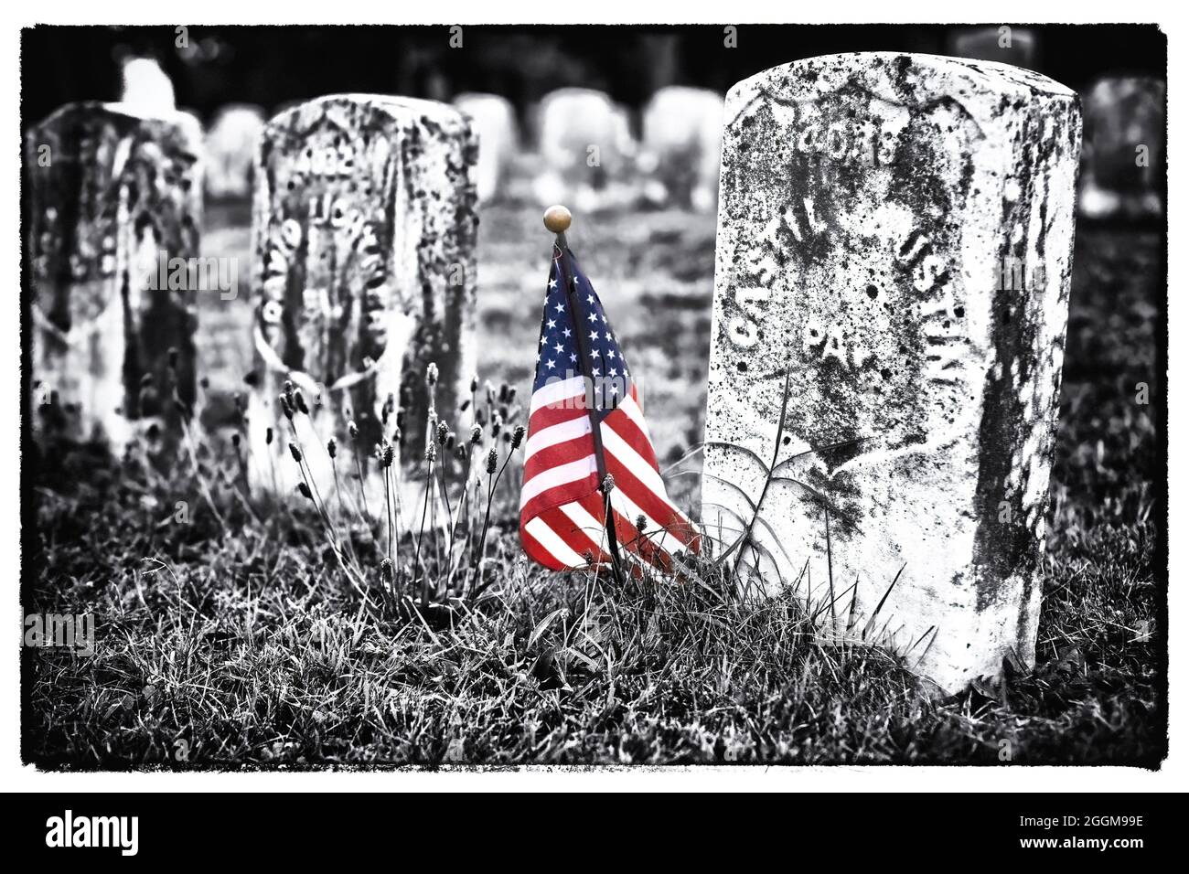 Farblich mit Graustufenfoto einer kleinen amerikanischen Flagge, die die Gräber von Todesopfern auf dem Antietam National Cemetery in Sharpesburg, Maryland, markiert. Stockfoto