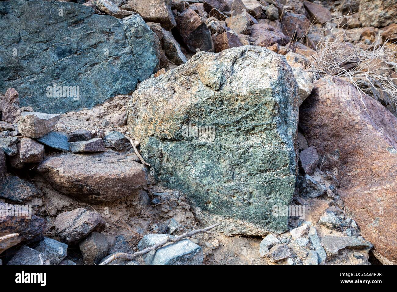 Rohes Erz aus Kupfer, grünen Steinen und kupferhaltigen Gesteinen im alten Bergbaugebiet, in den Bergen des Gebirges von Hagar, Vereinigte Arabische Emirate. Stockfoto