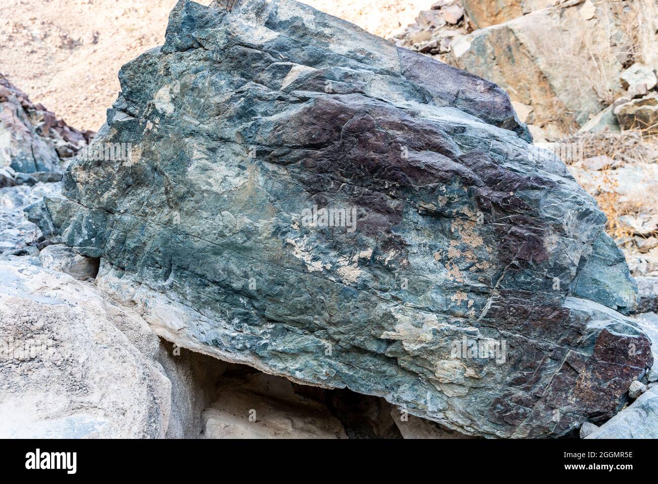 Rohes Erz aus Kupfer, grünen Steinen und kupferhaltigen Gesteinen im alten Bergbaugebiet, in den Bergen des Gebirges von Hagar, Vereinigte Arabische Emirate. Stockfoto