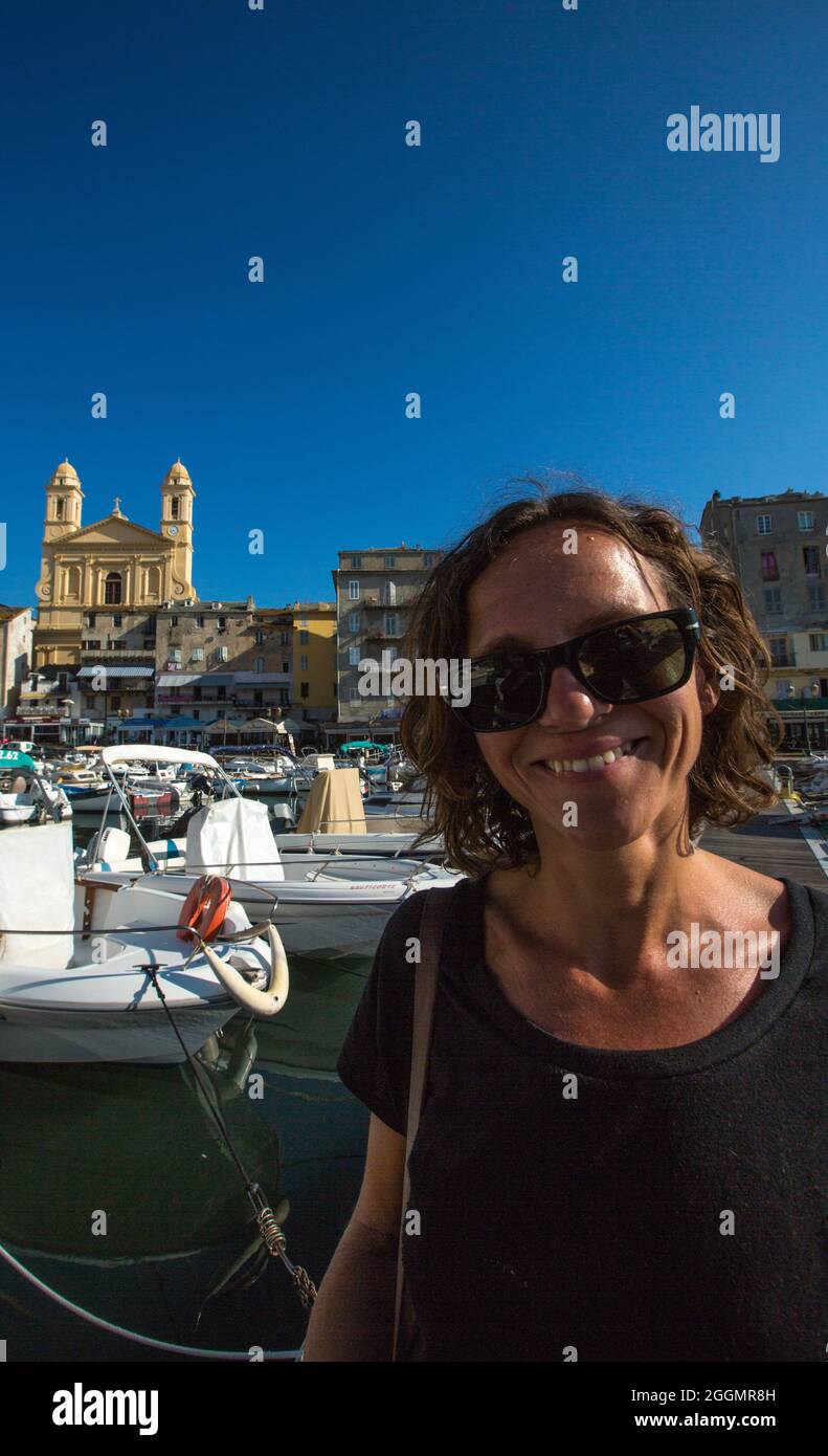 FRANKREICH. HAUTE-CORSE (2B) BASTIA. ALTER HAFEN, TURIST MIT KIRCHE SAINT-JEAN BAPTISTE IM HINTERGRUND Stockfoto