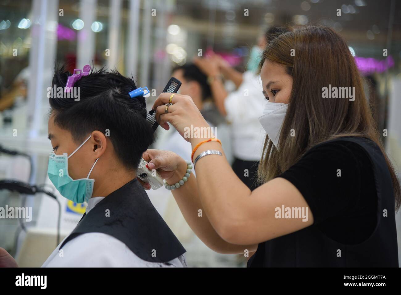 Nonthaburi, Thailand. September 2021. Chalachol Friseursalon, der an einem Kunden arbeitet, während die thailändische Regierung die Sperre teilweise aufhebt, sodass einige Unternehmen wieder öffnen können, indem sie Bedingungen wie soziale Distanzierung und das Tragen von Schutzmasken befolgen. (Foto: Yuttachai Kongprasert/SOPA IMA/Sipa USA) Quelle: SIPA USA/Alamy Live News Stockfoto