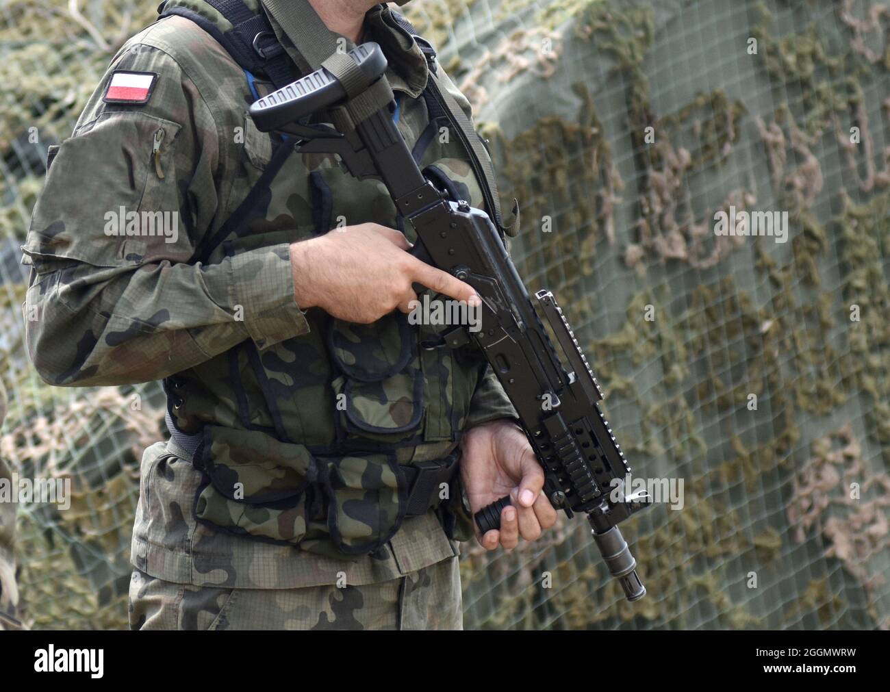 Soldat Polens mit Sturmgewehr und Flagge Polens auf Militäruniform. Polnischer Soldat mit Sturmgewehr. Stockfoto