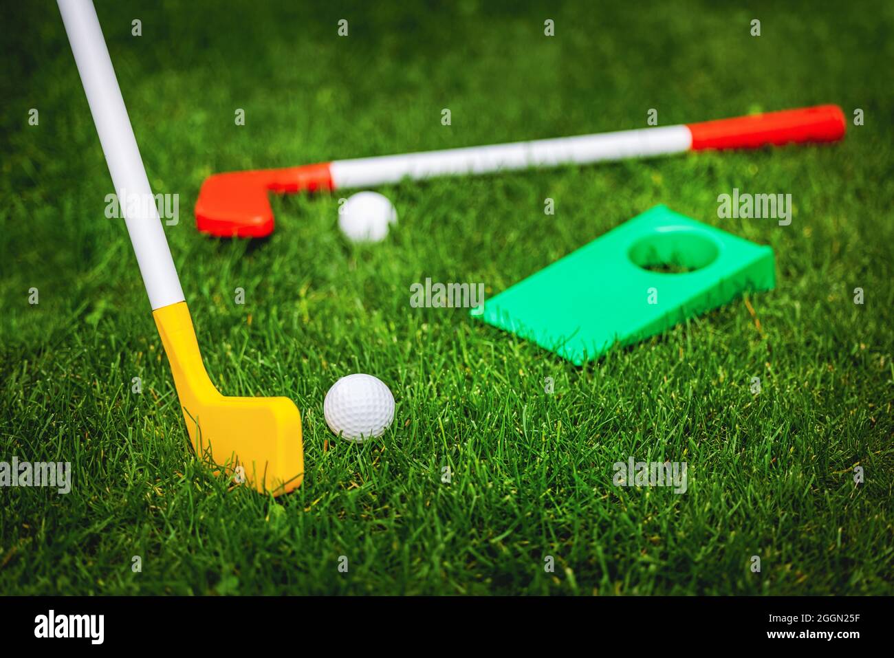Spielzeug-Golfspiel auf grünem Gras gesetzt. Gartenspiele Stockfoto