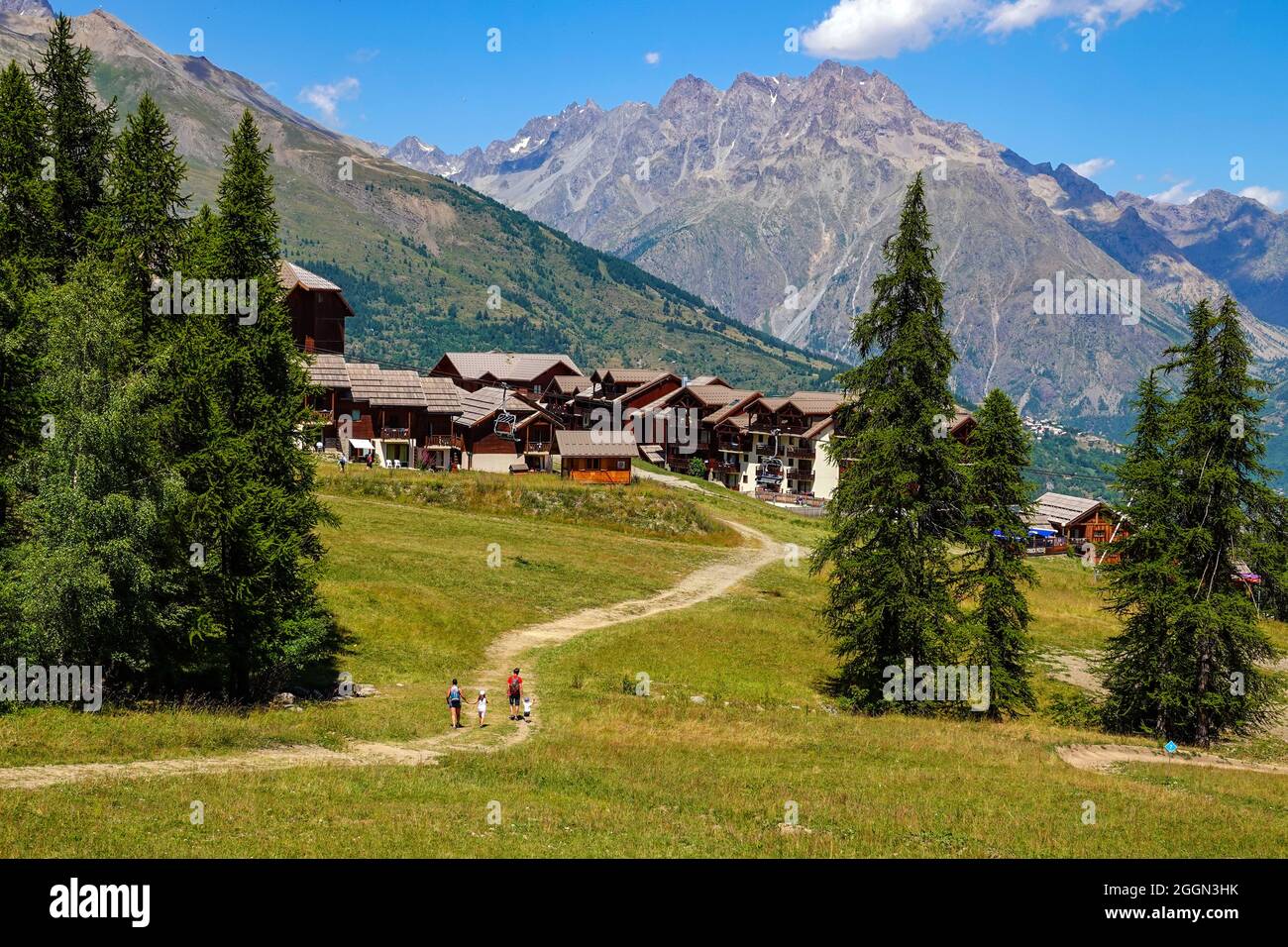 Vierköpfige Familie Wandern durch Wiesen, Sommer im Skigebiet Puy-Saint-Vincent, Ecrins, Französische Alpen, Frankreich Stockfoto