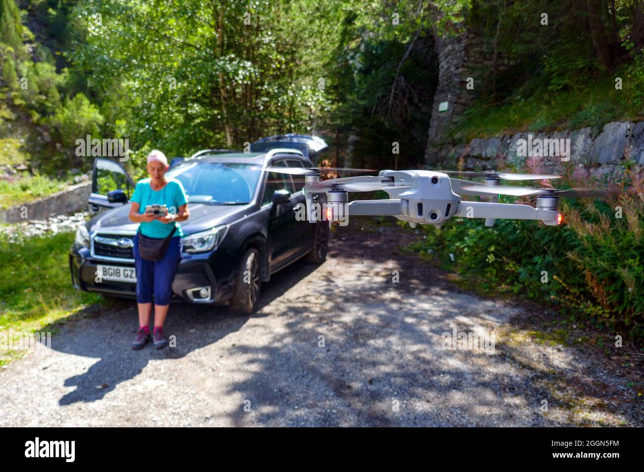 Eine Frau, die DJI-Drohne vor dem Auto bedient Stockfoto
