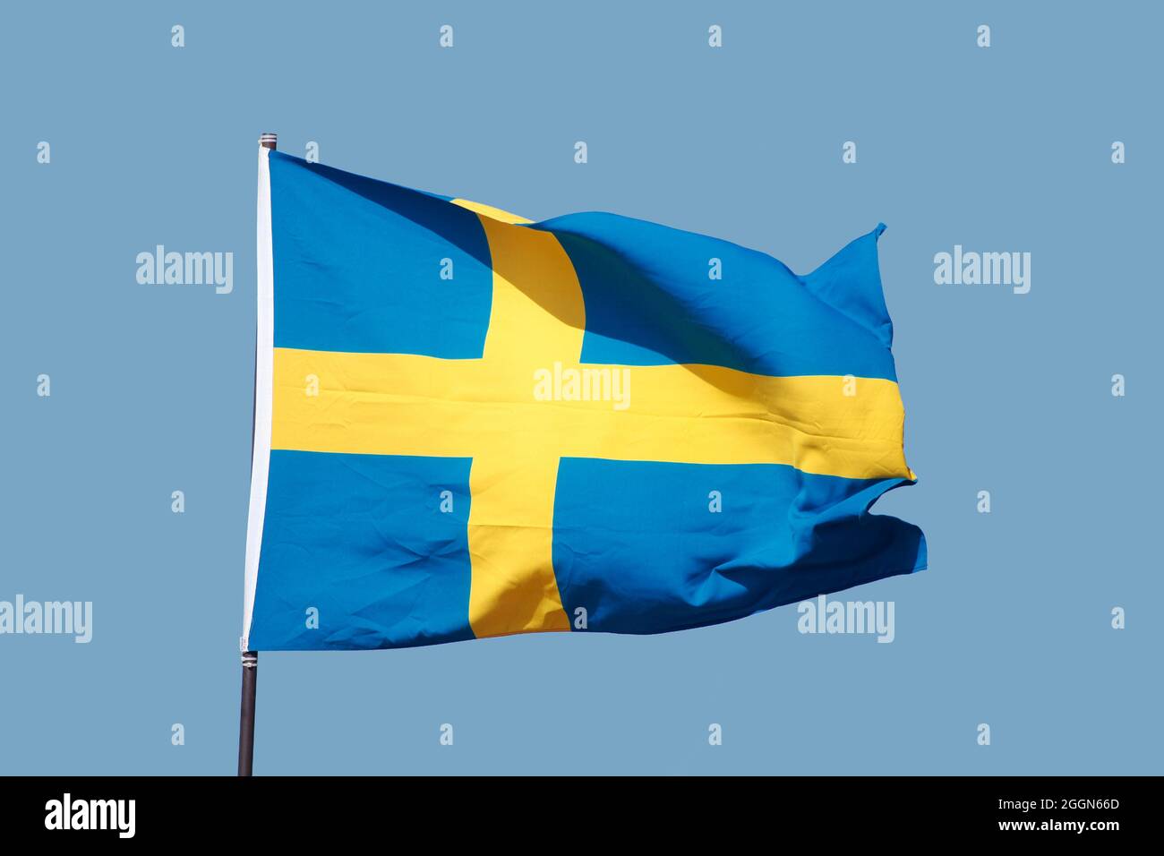 Schwedische Flagge auf Fahnenmast auf blauem Himmel Hintergrund fliegen Stockfoto