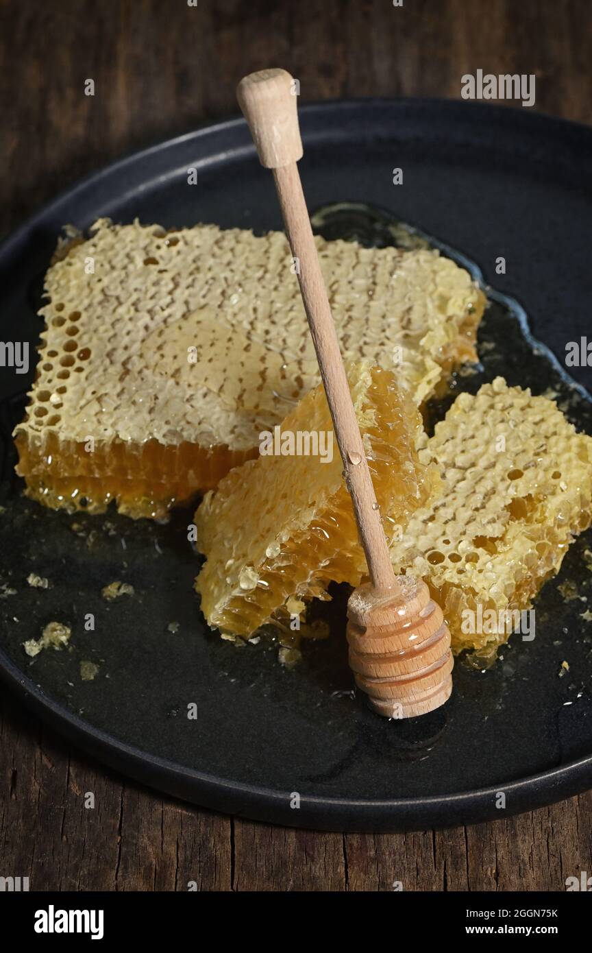 Nahaufnahme Honigwabe und Honigtaue auf Holztisch Stockfoto