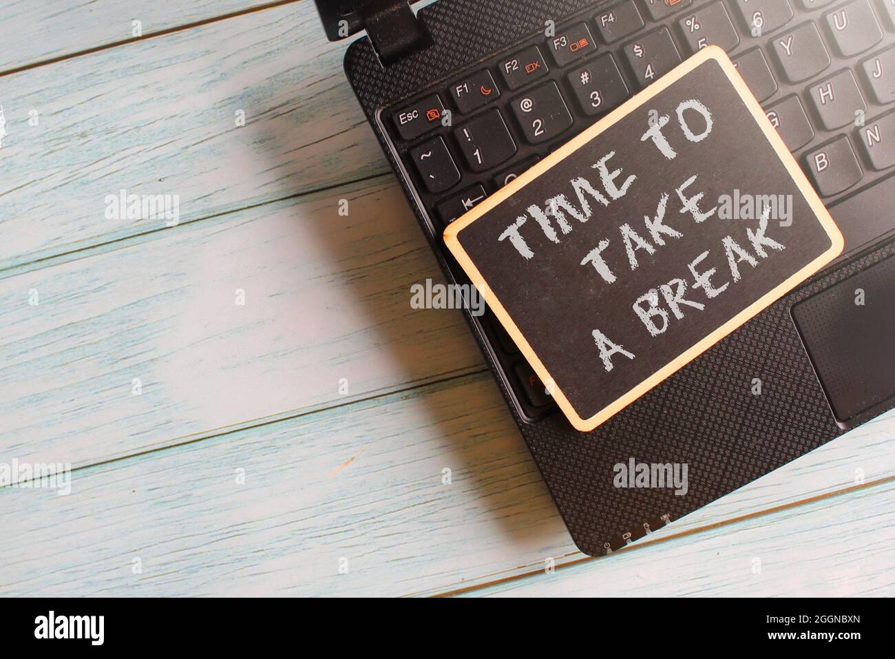 Draufsicht auf Laptop und Mini-Tafel mit TEXTDAUER FÜR EINE PAUSE. Platz für Text kopieren Stockfoto