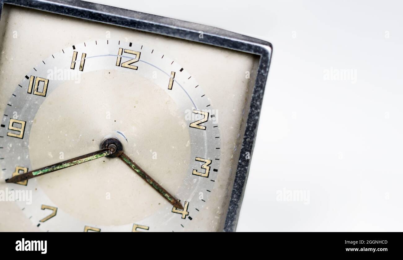 Alte, abgenutzte Uhr mit quadratischem Zifferblatt, isoliert auf weißem Hintergrund. Analoge Zeitmessung. Vintage- und Retro-Objekt. Speicherplatz kopieren. Stockfoto