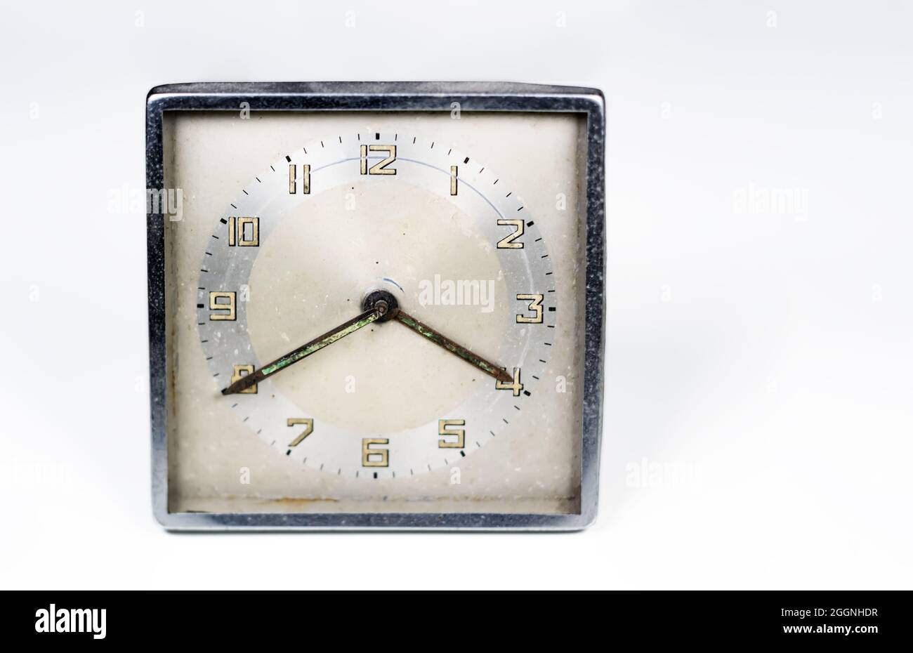 Alte, abgenutzte Uhr mit quadratischem Zifferblatt, isoliert auf weißem Hintergrund. Analoge Zeitmessung. Vintage- und Retro-Objekt. Speicherplatz kopieren. Stockfoto