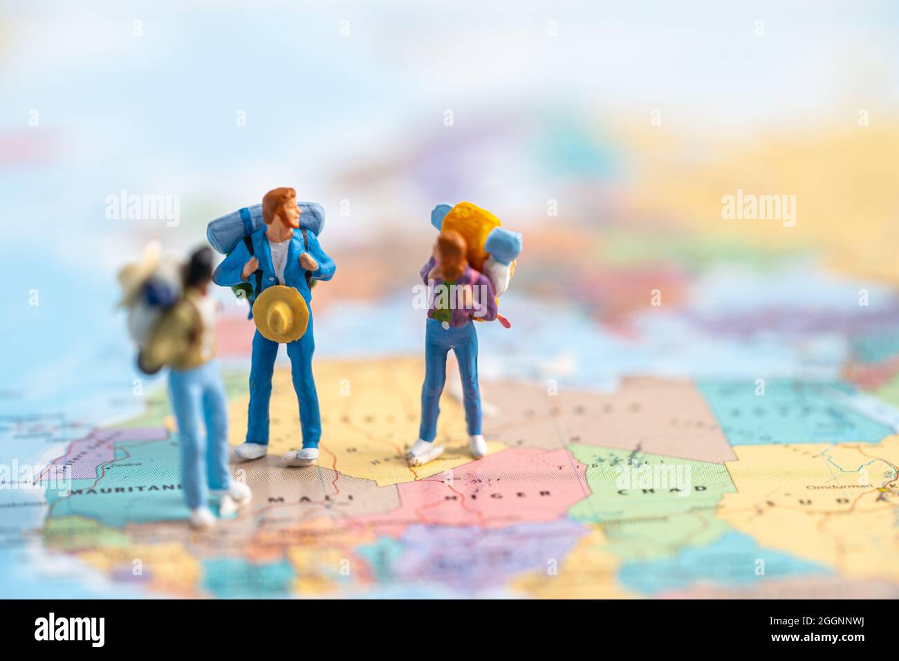 Miniaturmenschen, zwei Rucksacktouristen genießen Entdeckungsreise auf Amazing on World Map. Stockfoto