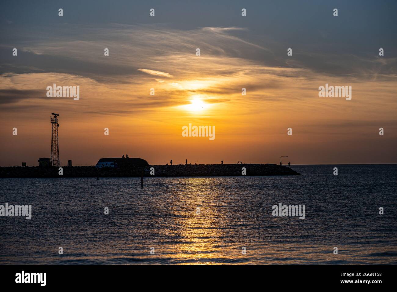 Ein herrlicher Sonnenuntergang über dem Meer. Himmel und Ozean leuchten orange Stockfoto