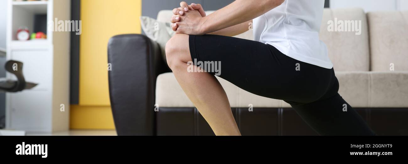 Die junge Frau führt sportliche Übungen durch, um die Beinmuskeln zu dehnen Stockfoto