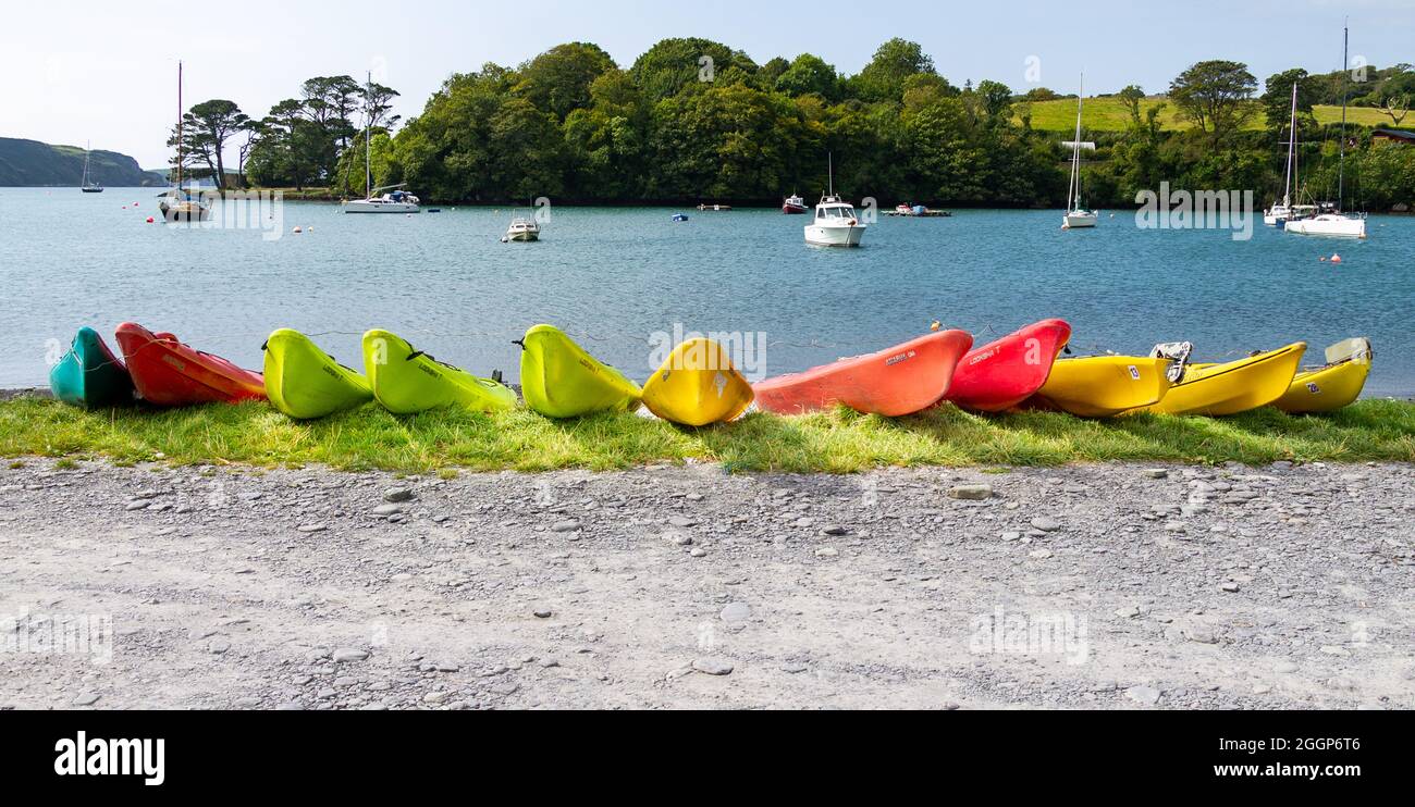 Farbige Kayak-Bögen Reihen sich am Wasserrand an Stockfoto