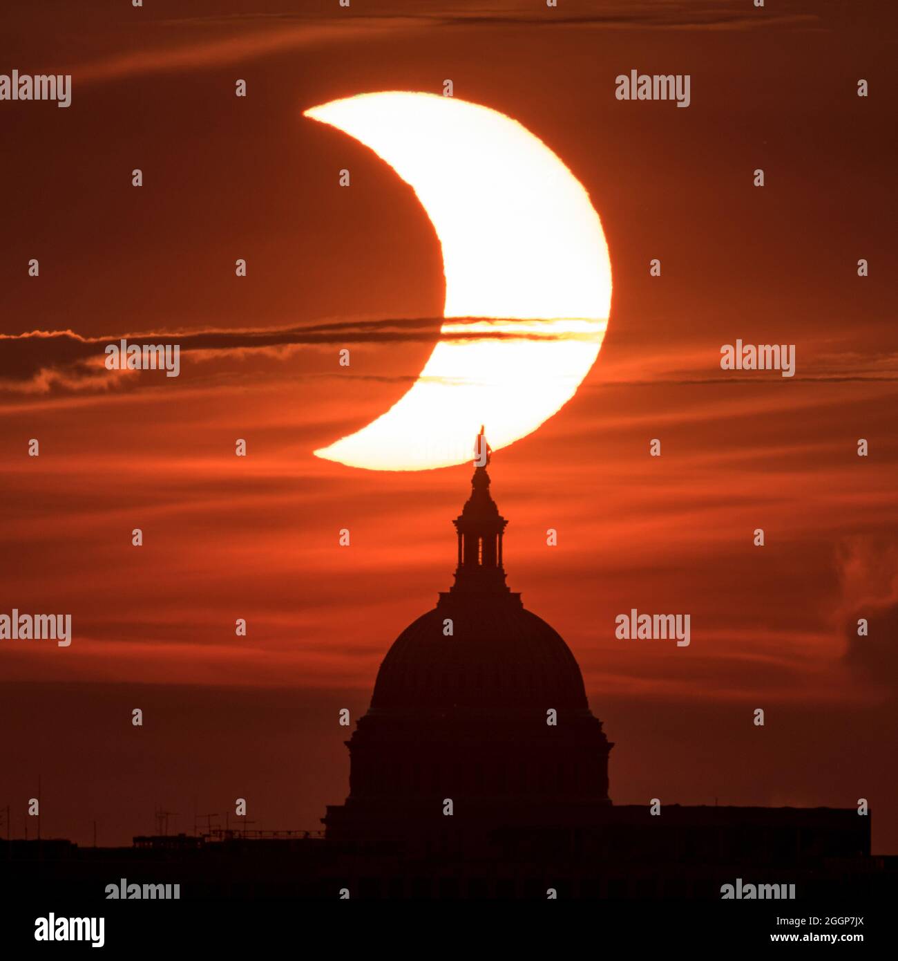 Am Donnerstag, dem 10. Juni 2021, wird ein teilweiser „Feuerring“ der Sonnenfinsternis gesehen, wenn die Sonne hinter der Freiheitsstatue auf dem Kapitolgebäude der Vereinigten Staaten aufgeht. Stockfoto