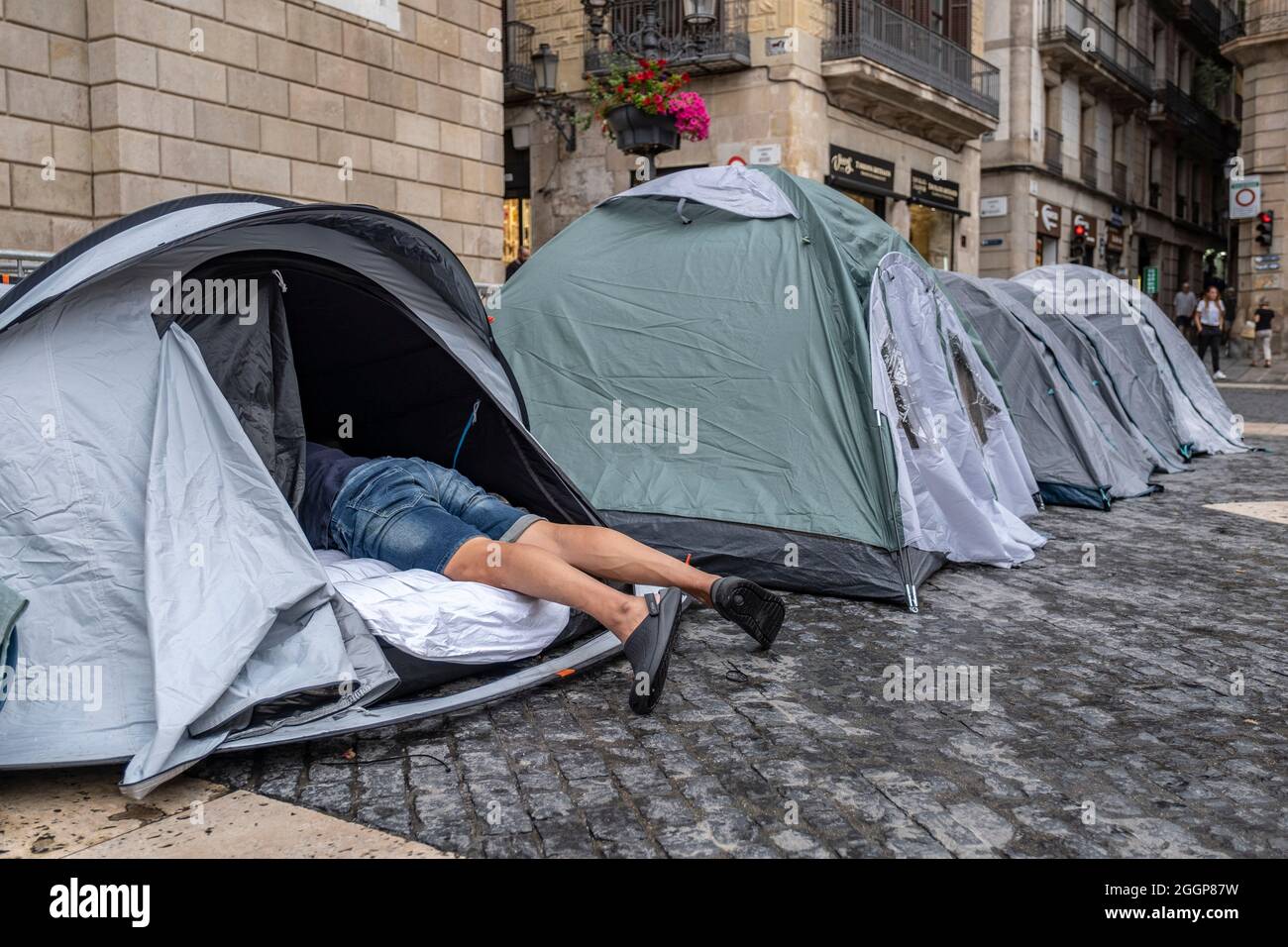 Barcelona, Spanien. September 2021. Einer der Camper wird während eines Streiks auf der Plaza de Sant Jaume im Zelt liegen sehen.der zweite Tag des Hungerstreiks auf der Plaza Sant Jaume wurde von Geschäftsleuten und Nachtlebens-Arbeitern nach dem TSJC (Supreme Court of Justice of Catalonia) durchgeführt. Bestätigte die Argumente der Generalitat de Catalunya, das Nachtleben wegen der sogenannten fünften Welle von Covid19 geschlossen zu halten. Kredit: SOPA Images Limited/Alamy Live Nachrichten Stockfoto
