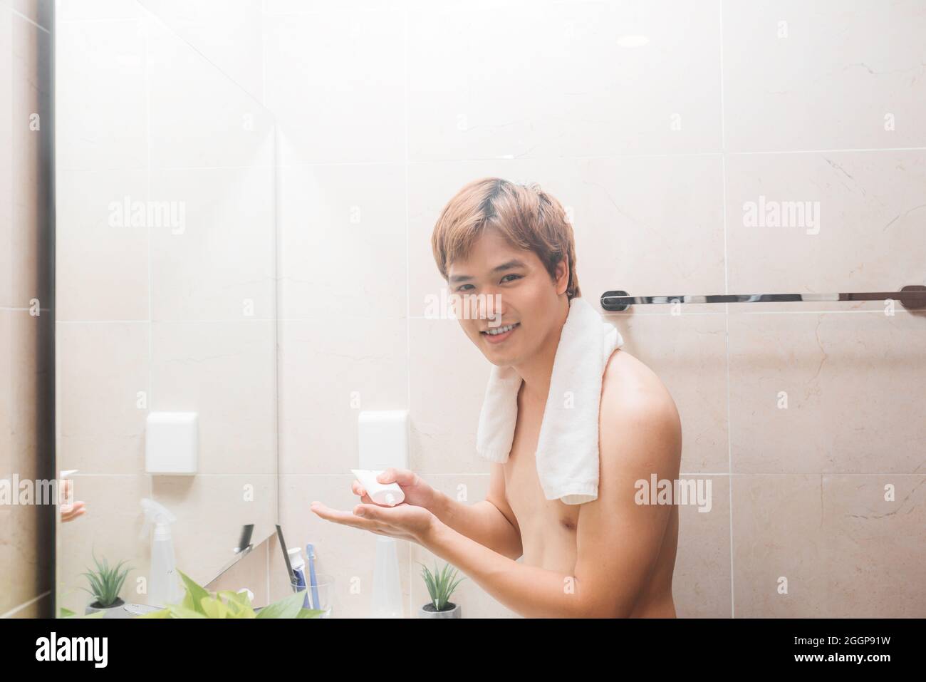 Der Mensch gießt Reinigungsmilch auf seine Hand Stockfoto