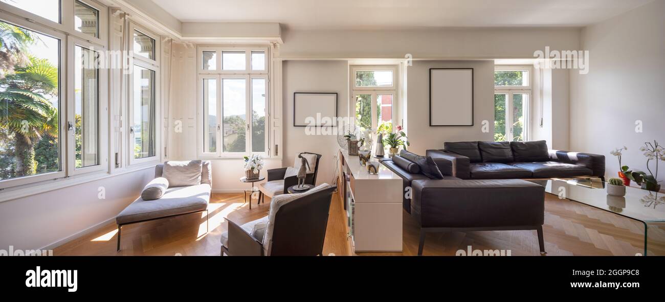 Panorama Elegantes Vintage-Wohnzimmer mit Ledersofa, Bücherregal, Sesseln und Chaiselongue. Elegante Villa. Parkettfußboden. Niemand drinnen. Stockfoto