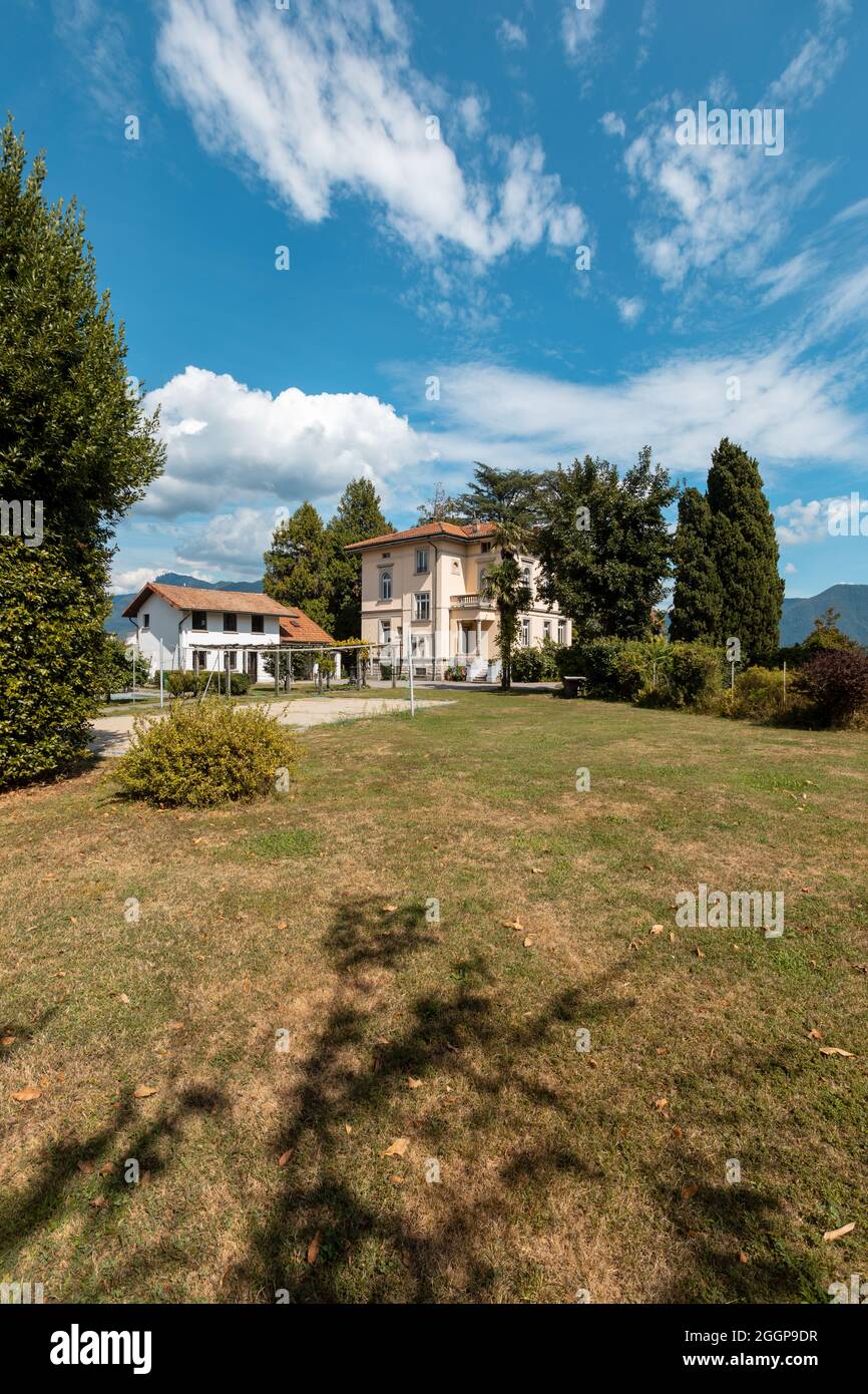 Große und alte Villa mit großem Garten um sie an einem sonnigen Sommertag Stockfoto