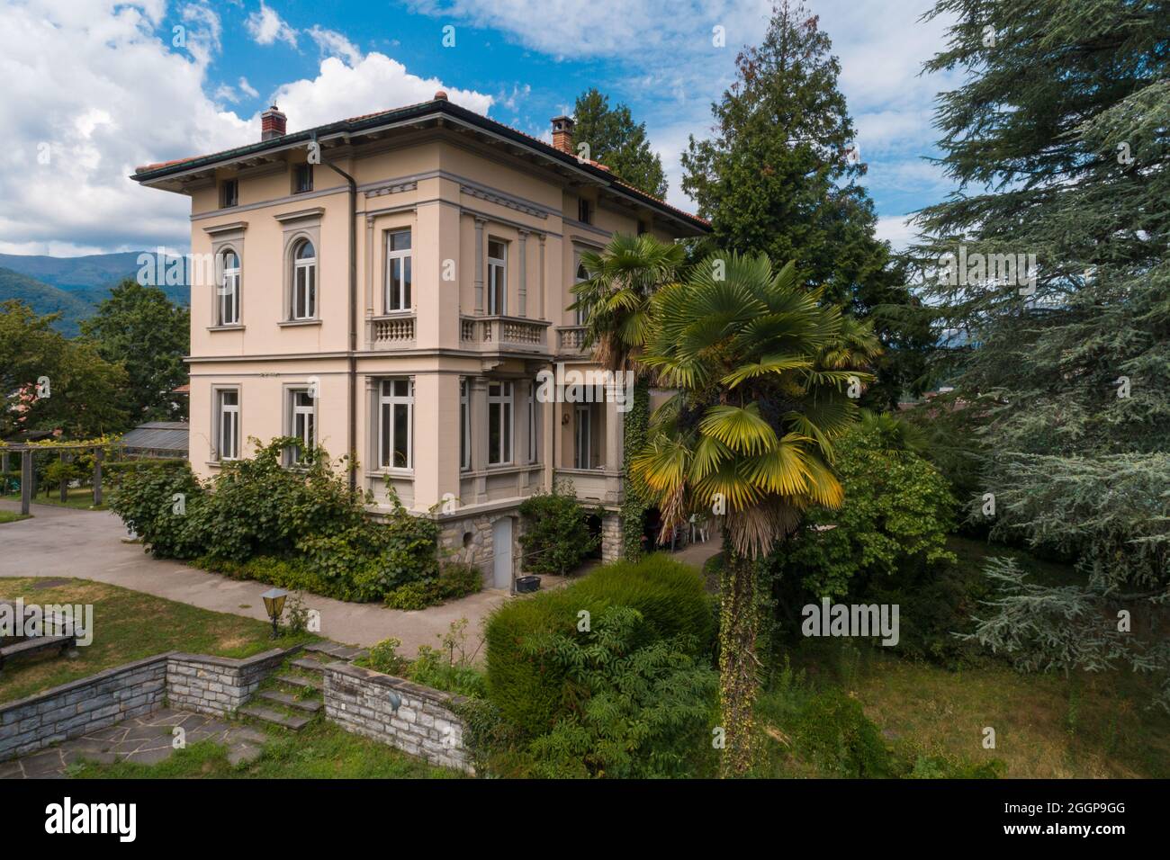 Große und alte Villa mit großem Garten um sie an einem sonnigen Sommertag Stockfoto