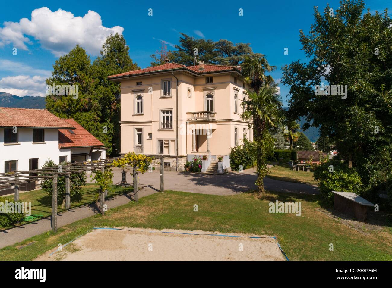 Große und alte Villa mit großem Garten um sie an einem sonnigen Sommertag Stockfoto