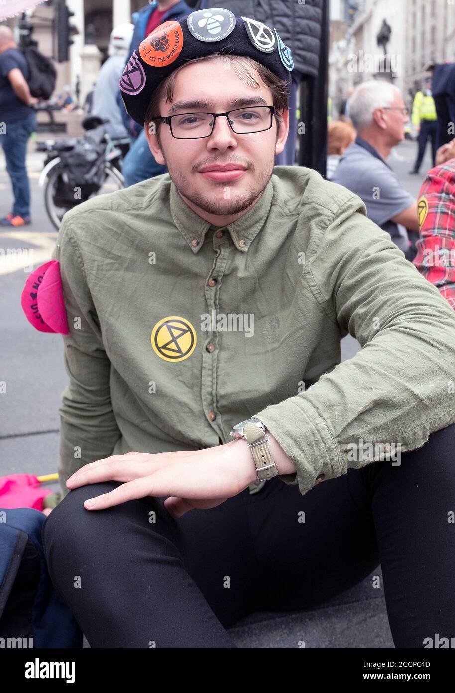 Ein Protestor, der mehrere Aufkleber für die Extinction Rebellion trägt, als die Extinction Rebellions sich während ihres Protestes für eine Massenfreitagsaktion am elften Tag ihrer Impossible Rebellion-Proteste in London, Großbritannien, am 2. September 2021 außerhalb der Bank of England aufmachen. Demonstranten, die während der Unmöglichen Rebellion verhaftet wurden, wurden ermutigt, den ganzen Tag über ihre Geschichten zu erzählen. Stockfoto