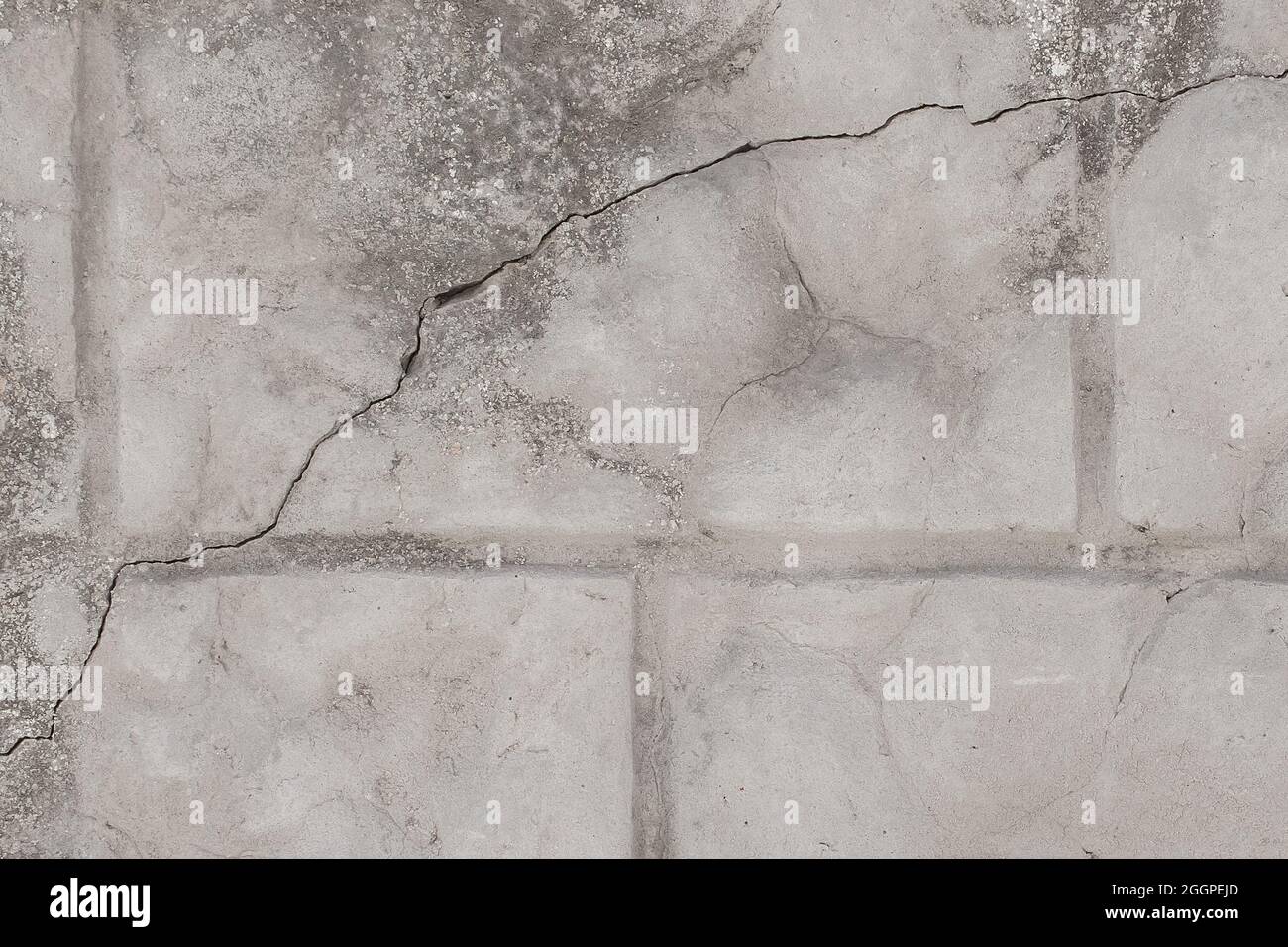 Verwitterte Backstein alten grauen gebrochenen Wand mit Rissen Textur beschädigt Stein Hintergrund. Stockfoto