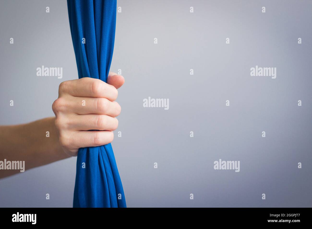 Aerialsilks Symbol, Hand der Frau mit blauem Aerialgewebe. Einladung zum Trainingskurs. Konzept der Tanzschule. Stockfoto