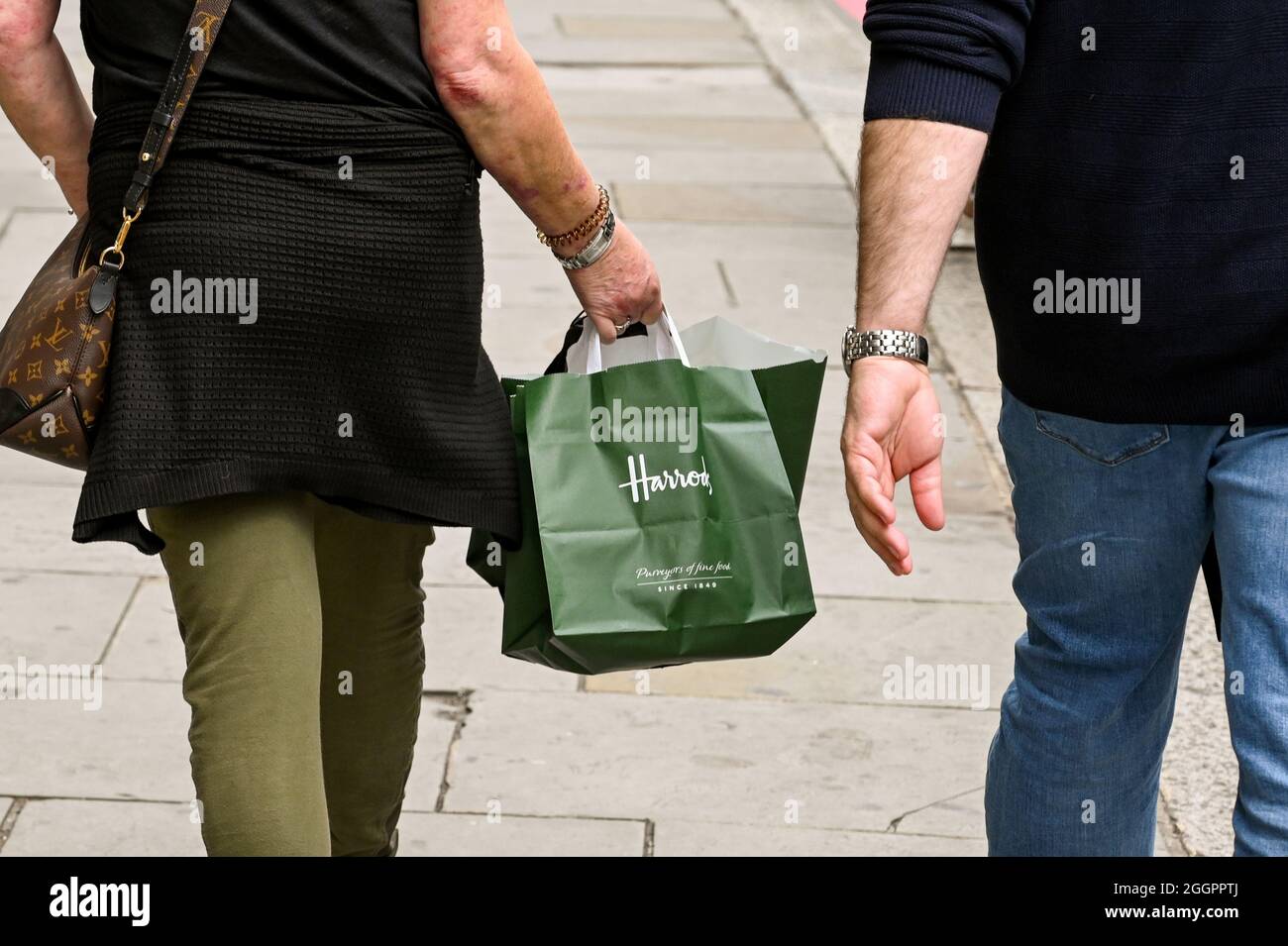 London, England - August 2021: Person, die eine kleine Tragetasche trägt, nachdem sie Waren in Harrods gekauft hat Stockfoto