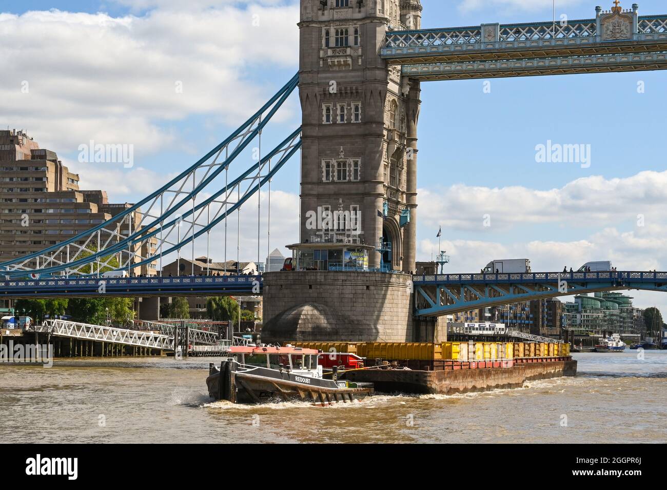 London, England - 2021. August: Industriebarge zieht ein Industriebarge an der Tower Bridge auf der Themse vorbei Stockfoto