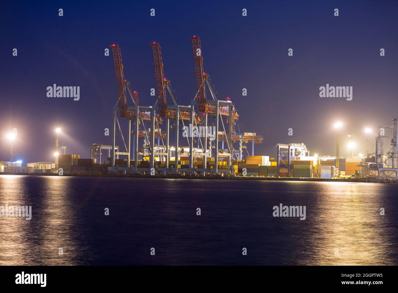 Industriehafen mit Containern bei Nacht. Container-Terminal des Industriehafens in der Nacht. Stockfoto