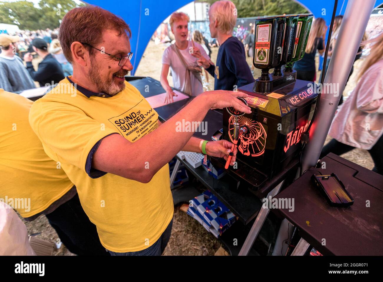 BORNHOLM, DÄNEMARK - 07. Aug 2021: Ein Mann, der ein Jagermeister-Alkoholgetränk für die Besucher des Konzerts in Bornholm, Dänemark, füllt Stockfoto