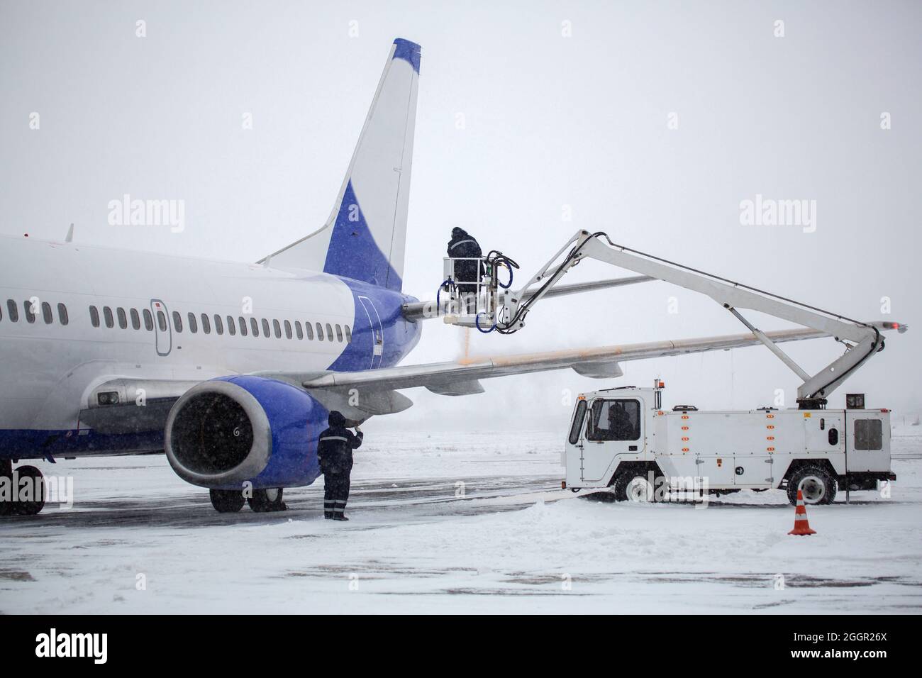 Schutz vor dem Einfrieren von Flugzeugen. Prozess der Abdeckung des Passagierflugzeugs mit Flüssigkeit gegen Einfrieren vor dem Abflug Stockfoto